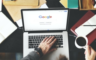 Photo from above of a person using a laptop on the Google website